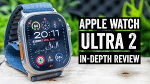 Apple Watch Ultra 2 with black titanium case displaying outdoor adventure interface on rugged terrain background